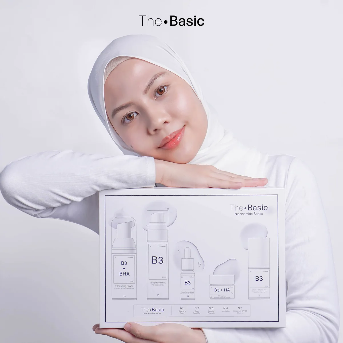 A hijab-wearing model holding the THEBASIC set in the official photoshoot